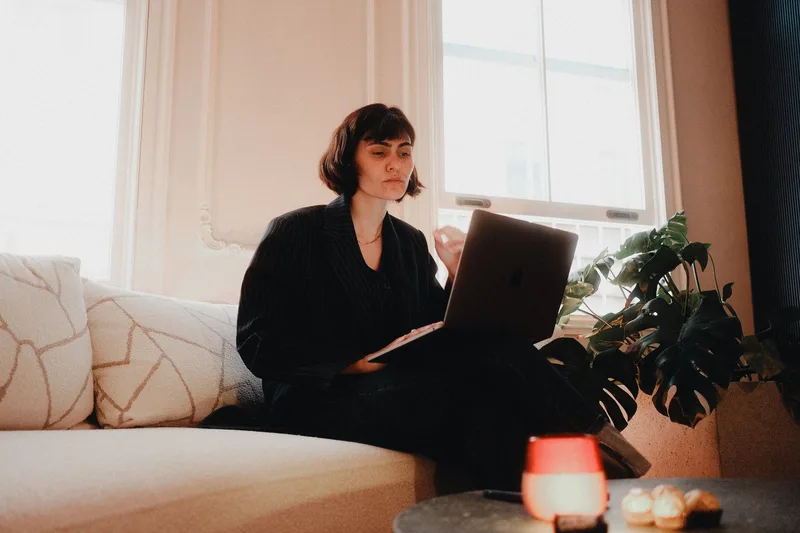 A bookkeeping VA working from home reviewing a client list and LinkedIn outreach on a laptop