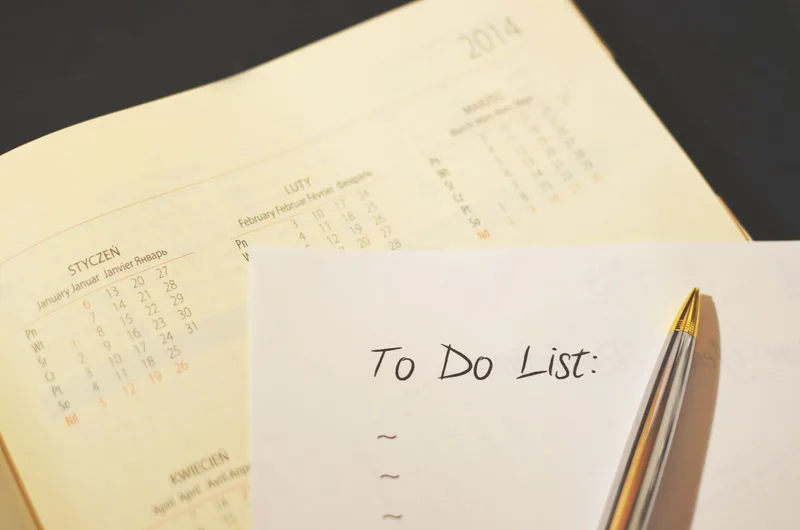 Calendar and checklist on a desk representing onboarding planning and task documentation