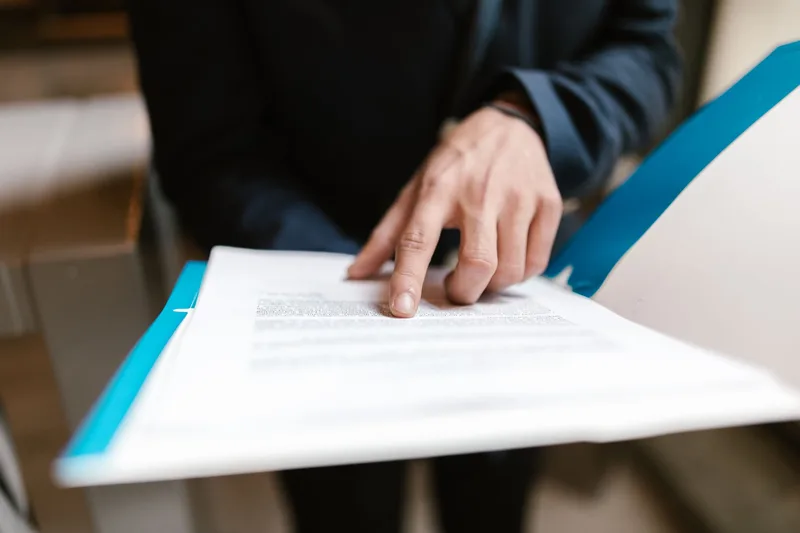 Person signing a client contract, an essential step in setting up a professional virtual assistant business