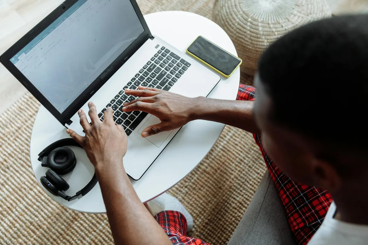 Person searching for virtual assistant jobs on a laptop at a home desk