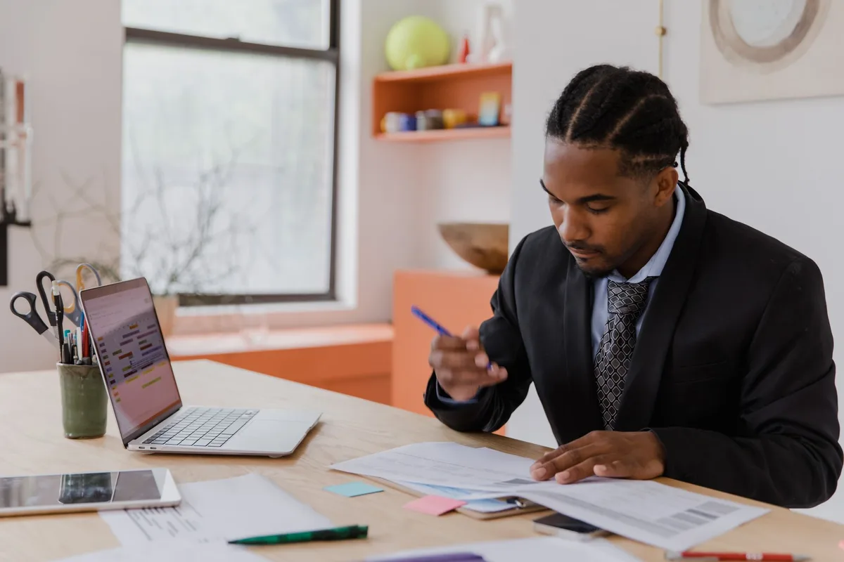 Business owner at his desk reviewing paperwork while researching hiring options