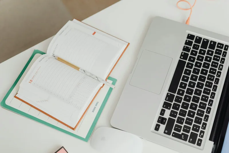 Executive assistant organizing a calendar and tasks on a laptop in a bright home office