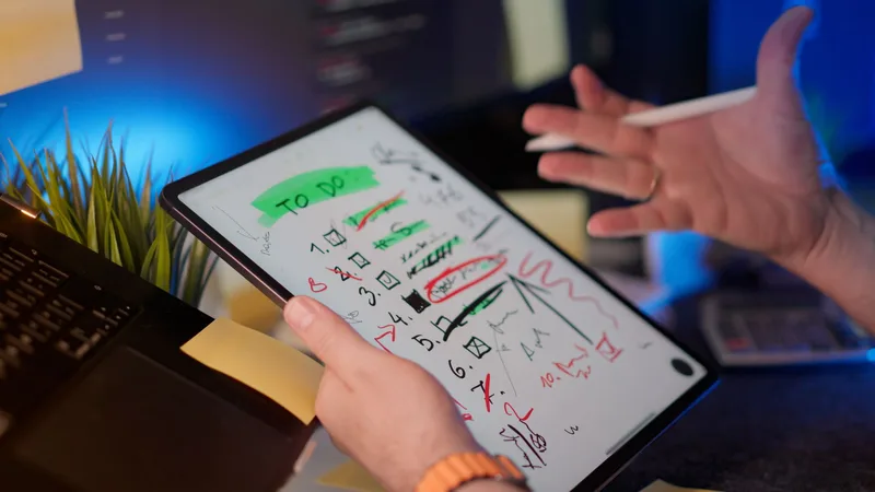A person managing a to-do list on a tablet at a desk