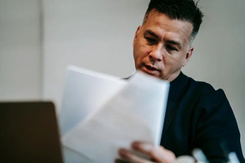 Small business owner reviewing virtual assistant evaluation criteria at a desk